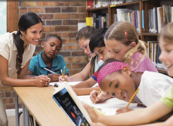 Teacher working with diverse students in a library classroom